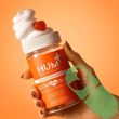 "Open bottle of HUM Glow Sweet Glow Skin 60 Vegan Gummies showing heart-shaped gummies – vegan and gluten-free."

