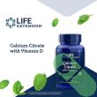 "Life Extension Calcium Citrate with Vitamin D 200 capsules bottle open, white capsules spilling onto table"

