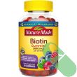 Gummies spilled beside Nature Made Biotin bottle showing product texture and size

